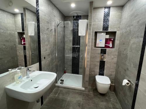 ein Bad mit einem Waschbecken, einem WC und einer Dusche in der Unterkunft I&M Apartments Krawiecka Wrocław in Breslau