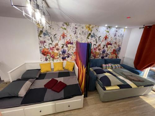 een slaapkamer met 2 bedden en een muurschildering bij T1/ terrasse /proche centre Lyon in La Mulatière