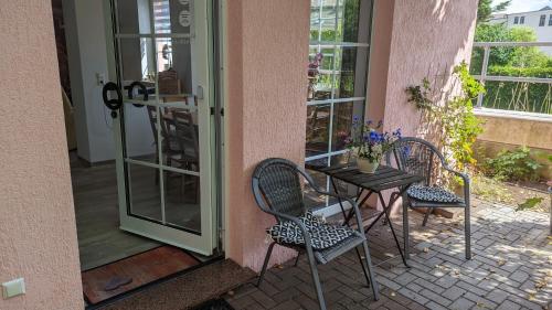 um pátio com duas cadeiras e uma mesa ao lado de uma porta em Ferienwohnung Kaminfeuer em Eilenburg