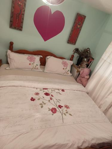 um quarto com uma cama com um coração roxo na parede em KEYHAVEN WALK em Manchester