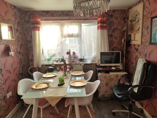 a dining room with a table and chairs and a television at KEYHAVEN WALK in Manchester