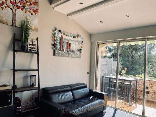 un salon avec un canapé en cuir et une table dans l'établissement LA CASA PALMITO appartement moderne coté mer, à Saint-Cyr-sur-Mer