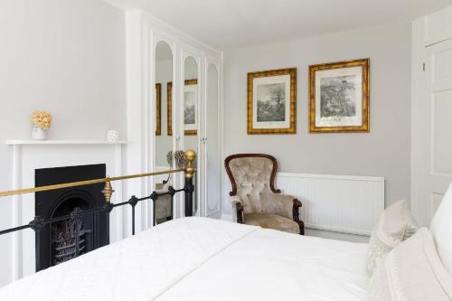 a bedroom with a bed and a fireplace at The Kept Cottage in Hassocks