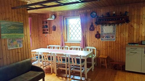 een keuken met een tafel en stoelen in een kamer bij Rekreačná Chata in Jakubovany