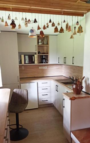 a kitchen with white cabinets and a chair in it at Rekreačná Chata in Jakubovany