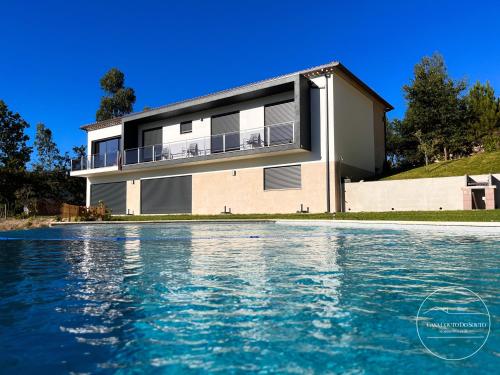 a house with a swimming pool in front of it at Casa Couto Do Souto in Souto