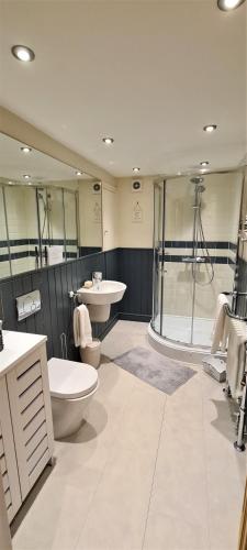 a bathroom with a shower and a toilet and a sink at The School House, Sowood, Halifax in Halifax