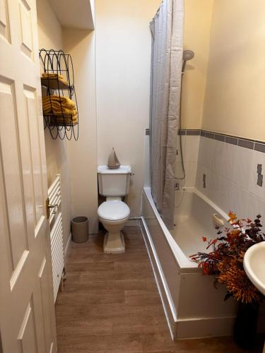 uma casa de banho com um WC, uma banheira e um lavatório. em Cosy Herne Bay Seaside Cottage em Kent