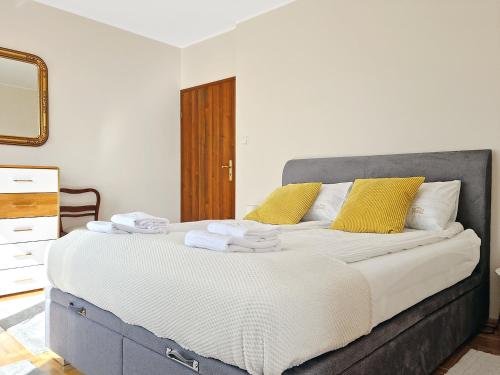 sypialnia z dużym łóżkiem z żółtymi poduszkami w obiekcie CLASSY APARTMENTS - Gdynia - Słoneczny w mieście Gdynia