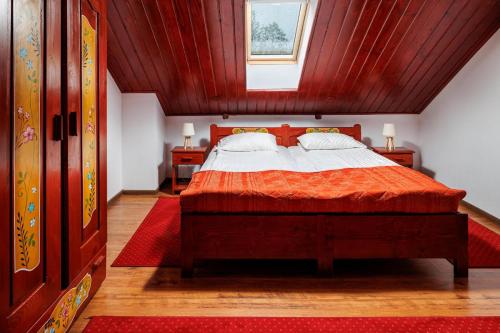 een slaapkamer met een bed met een rood dekbed bij Pensiunea Tanita in Bran