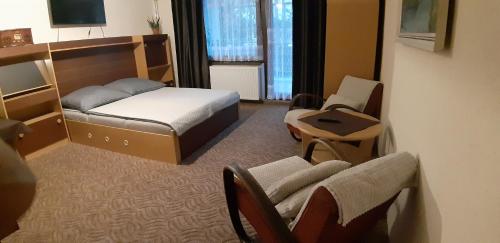 Habitación de hotel con cama, silla y escritorio. en Max, en Liptovský Mikuláš