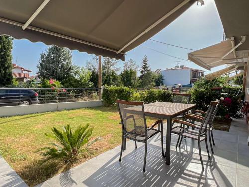 een tafel en stoelen op een patio met een tuin bij Kalisti Relax Villa in Nikiti