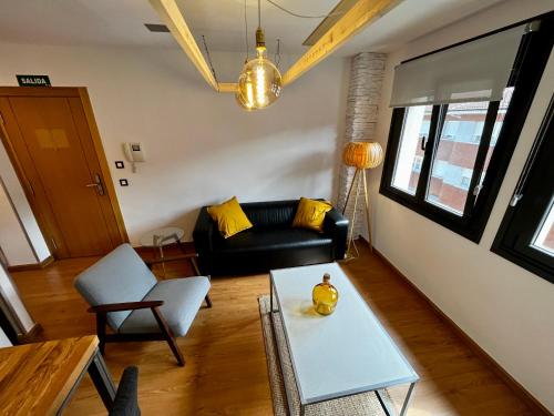 a living room with a black couch and a table at Lotila Flats Cabañaquinta in Aller