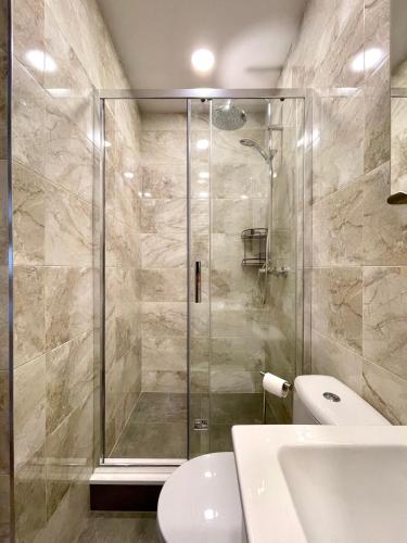 La salle de bains est pourvue d'une douche, de toilettes et d'un lavabo. dans l'établissement Apartament Centrum, à Supraśl