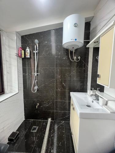 uma casa de banho com um chuveiro e um lavatório. em Your Joyful Spot em Shkodër