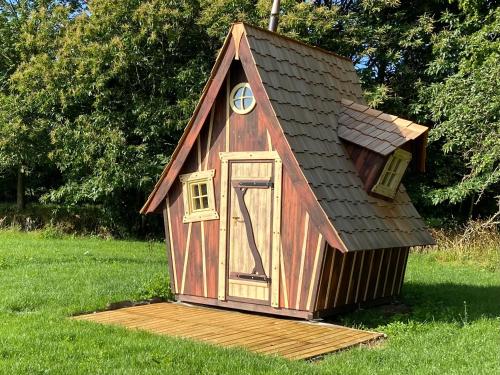 a dog house with a roof on the grass at LES INSOLITES DE SOPHIE 