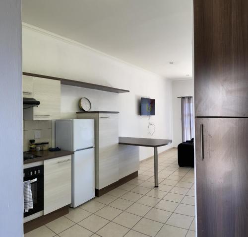 a kitchen with a refrigerator and a table in it at H&H Self-catering in Windhoek