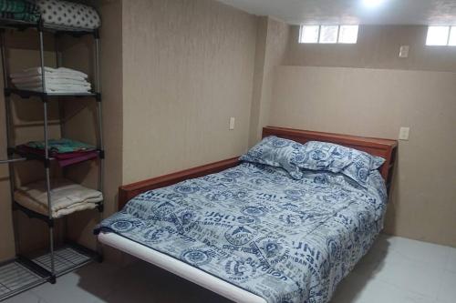 grupos familiares 2 في Xochimilco: غرفة نوم بسرير لحاف ازرق وبيض