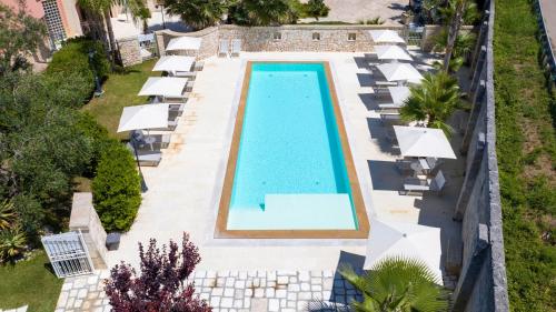 - une vue sur une piscine avec des chaises longues et un complexe dans l'établissement Villa Rosa Antico Dimora Storica, à Otrante