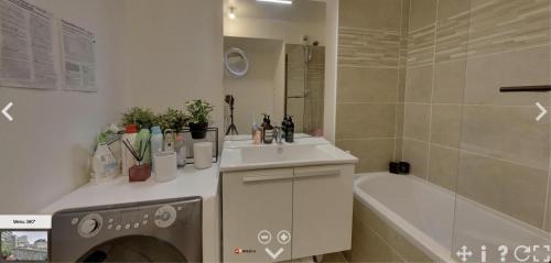 a bathroom with a sink and a bath tub at Spacious flat with terrasse and parking near metro in Bagnolet