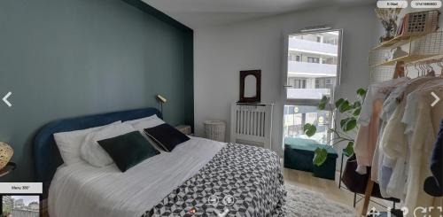 um quarto com uma cama e uma janela em Spacious flat with terrasse and parking near metro em Bagnolet
