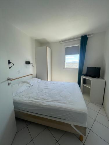 une chambre avec un lit, une fenêtre et une télévision dans l'établissement Appartement-Maison 2 chambres vue exceptionnelle, au Barcarès