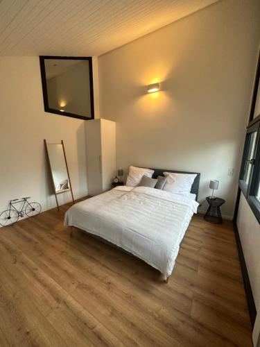 a bedroom with a white bed and a flat screen tv at Traumhafte Architekten-Doppelhaushälfte in Unterschleißheim