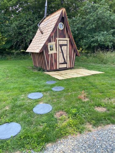 a dog house with a door in the grass at LES INSOLITES DE SOPHIE 