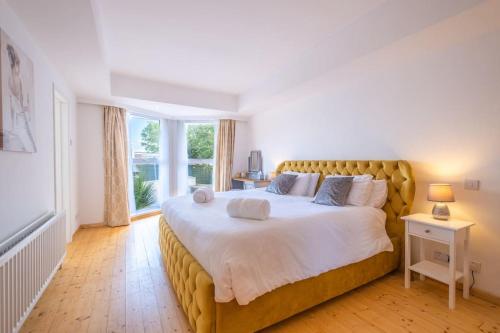 a bedroom with a large bed with a large window at Port Tara Holiday Home in Portballintrae