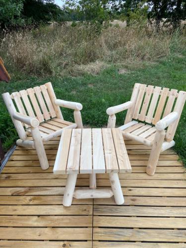 twee houten stoelen en een picknicktafel op een terras bij LES INSOLITES DE SOPHIE 