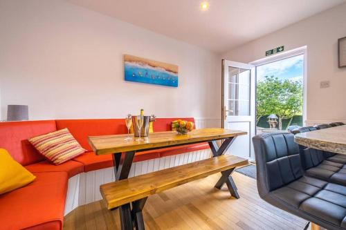 a living room with a red couch and a table at Port Tara Holiday Home in Portballintrae