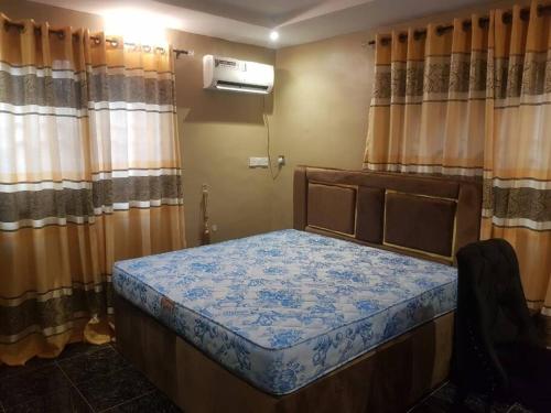 - un petit lit dans une chambre avec des rideaux dans l'établissement 3JD Lavishly Furnished 1-Bed Apt, à Lagos