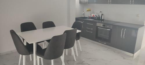 ゴーレムにあるGolem Apartment Luxuryのキッチン(白いテーブル、黒い椅子付)