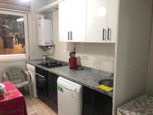 a kitchen with white cabinets and a counter top at MEYDANDA 1+1 DAİRE in Trabzon