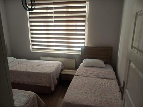 a small room with two beds and a window at MEYDANDA 1+1 DAİRE in Trabzon