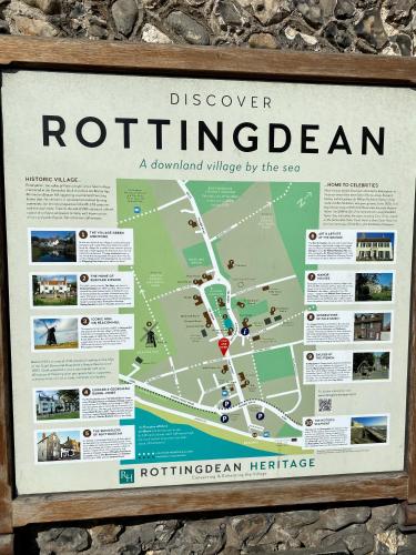 a sign hanging on a wall with a map at Rottingdean Boutique Studio Apartment By The Sea in Rottingdean