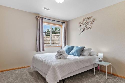 ein Schlafzimmer mit einem weißen Bett und einem Fenster in der Unterkunft Convenient Townhouse - Near Airport in Rapid City