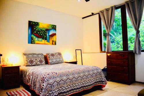 a bedroom with a bed and a dresser and a window at Casa de Ali: Located on the beach! in Zihuatanejo