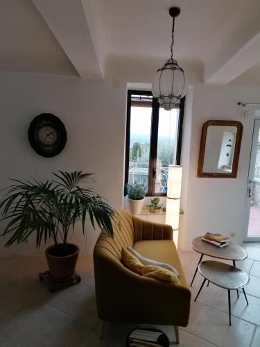 un salon avec un canapé et une plante en pot dans l'établissement Chambre d'hôte, à Crillon-le-Brave