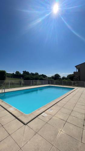 - une grande piscine bleue au soleil dans l'établissement Appartement T2 avec piscine, à Mirepoix