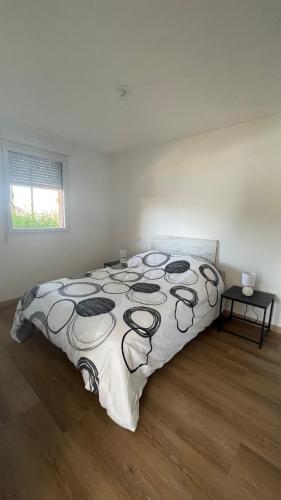 une chambre avec un lit avec une couette noire et blanche dans l'établissement Appartement T2 avec piscine, à Mirepoix