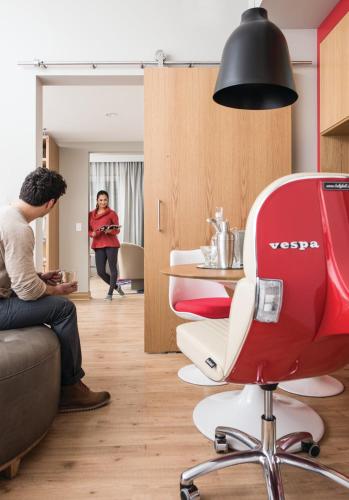 a woman standing in a room with a red chair at Virgin Hotels Chicago in Chicago