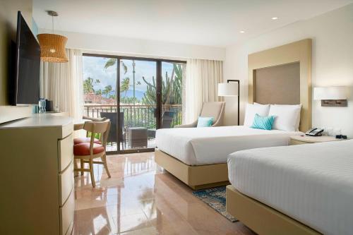 a hotel room with two beds and a balcony at Marriott Puerto Vallarta Resort & Spa in Puerto Vallarta