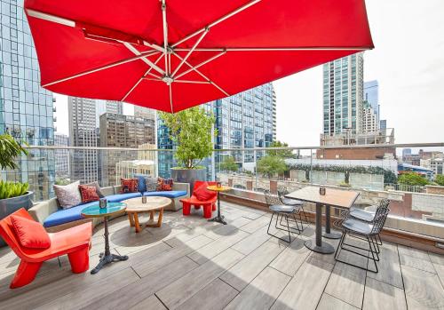 a patio with tables and chairs and a red umbrella at Virgin Hotels Chicago in Chicago