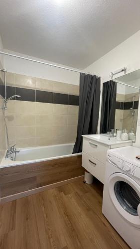 une salle de bain avec baignoire et machine à laver dans l'établissement Appartement T2 avec piscine, à Mirepoix
