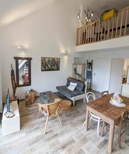 un salon avec une table et un canapé dans l'établissement Le Rocky Lodge Large cottage with wooden deck and private garden next to Fontainebleau Forest, à Achères-la-Forêt