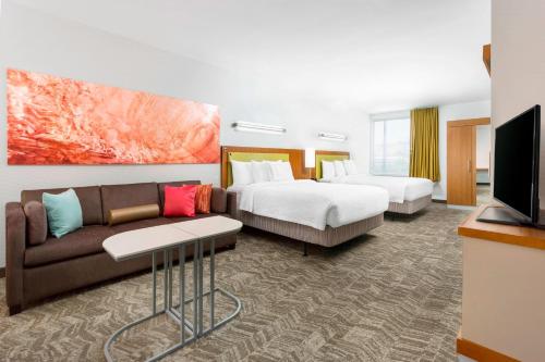 a hotel room with two beds and a couch and a tv at SpringHill Suites by Marriott San Diego Mission Valley in San Diego