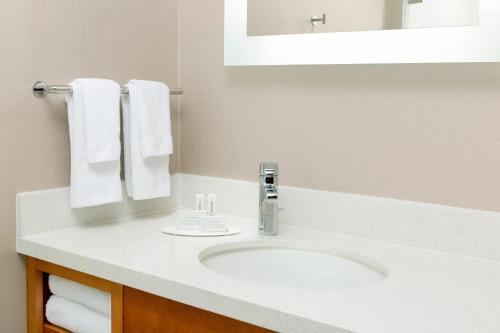 a bathroom with a sink and a mirror and towels at SpringHill Suites by Marriott San Diego Mission Valley in San Diego