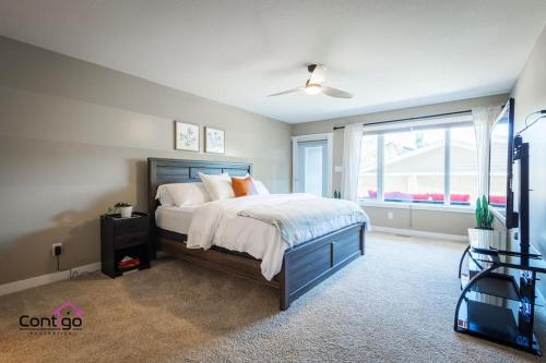 a bedroom with a large bed and a window at Lux Haven, Sleeps 8, AC, Balcony, Close to YQL in Lethbridge