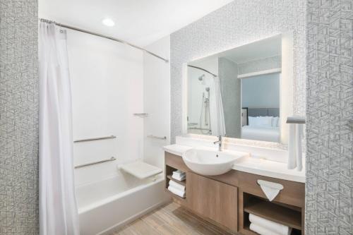 La salle de bains blanche est pourvue d'un lavabo et d'un miroir. dans l'établissement SpringHill Suites by Marriott Panama City Beach Beachfront, à Panama City Beach